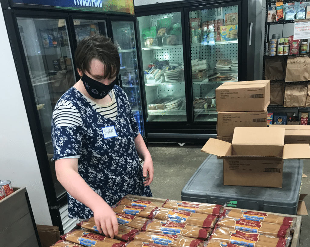 Female store employee organizing products in a bin.